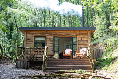 Log cabin outside with the fire pit going
